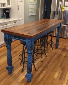 a kitchen island with stools in front of it