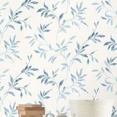 the wallpaper is blue and white with green leaves on it, along with two vases