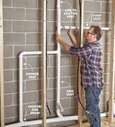 a man is working on the plumbing in his new home, which is under construction