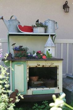 an old fashioned stove with pots and pans on it's top is in the garden