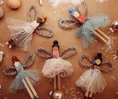 several small wooden dolls sitting on top of a table next to christmas ornaments and pencils