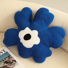 a blue stuffed animal sitting on top of a white couch next to a magazine cover