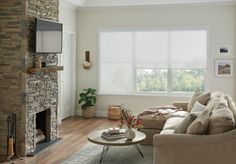 a living room filled with furniture and a flat screen tv mounted on the wall above a fire place