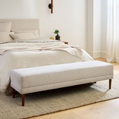 a white bed sitting on top of a wooden floor