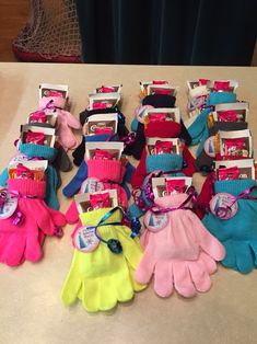 there are many pairs of gloves and mittens on the table with other items in them