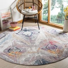 a round rug with an abstract design on the floor in front of a large window