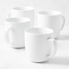 four white coffee mugs sitting next to each other