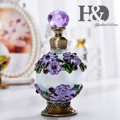 the perfume bottle is decorated with purple flowers