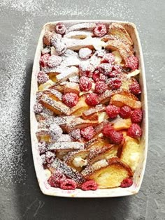 french toast struda with raspberries and powdered sugar in a casserole dish