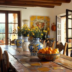 a table with oranges and vases on it in the middle of a room