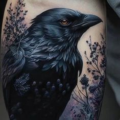 a black bird with flowers on it's arm