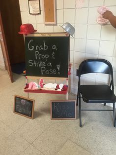 a blackboard with writing on it next to two chairs and a sign that says grab a prop & strike a pose