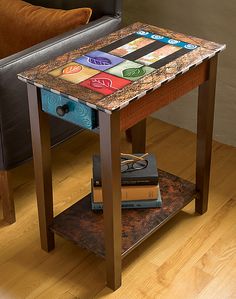 an end table with books on it and a couch in the background