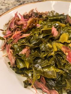 a white plate topped with greens and meat