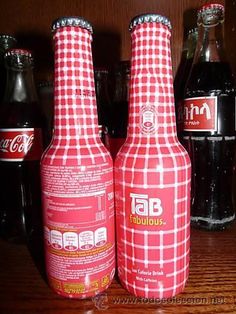 two red and white bottles sitting on top of a wooden table