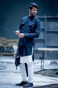 a man standing in front of a table holding a cup