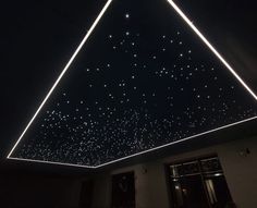 the ceiling is lit up with white lights and stars in the night sky above it