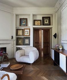 a living room filled with furniture and pictures on the wall