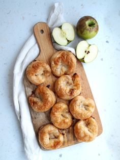 some apples are sitting on a cutting board next to other food items and a white towel