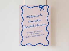 a pink and blue sign hanging on a wall