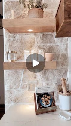 a kitchen with stone walls and wooden shelves