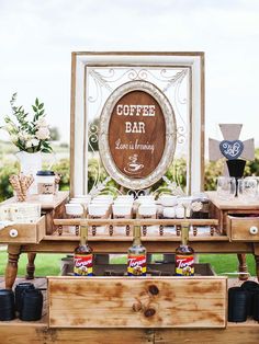 an outdoor coffee bar is set up on a wooden table