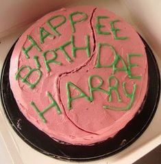 a pink birthday cake with green writing on it