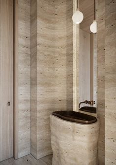 a bathroom with wooden walls and a round tub in the middle, surrounded by two lights