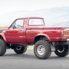 a red pick up truck parked in a parking lot