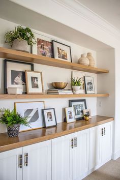 some shelves with pictures and plants on them