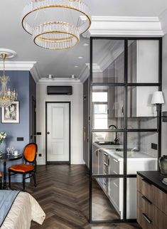 a bedroom with a bed, chair and chandelier