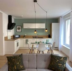 a living room filled with furniture next to a kitchen