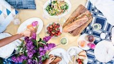 people sitting at a table with food on it and plates in front of the table