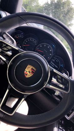 the steering wheel and dashboard of a porsche car