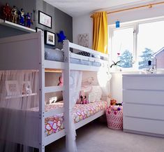 a white bunk bed sitting next to a window