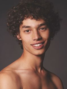 a young man with curly hair and no shirt