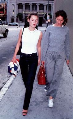 two women are walking down the sidewalk together