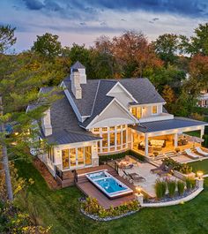 an aerial view of a house with a pool and hot tub in the yard at dusk