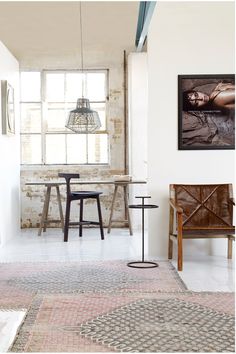 a living room filled with furniture and a painting hanging on the wall next to a window