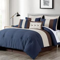 a bed with blue and brown comforters in a room