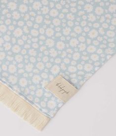 a blue and white flowered blanket with a tag on it