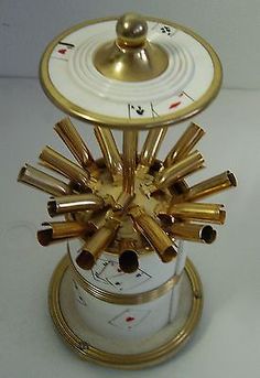 a clock that is sitting on top of a white table with gold trimmings