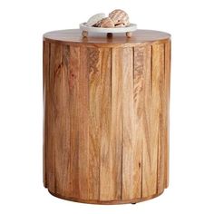 a wooden table with a bowl on top and shells in the middle, against a white background