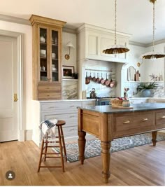 a kitchen with an island in the middle and two stools next to it,