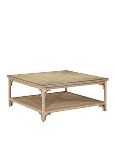 a square coffee table with an open shelf underneath it and wicker on the bottom