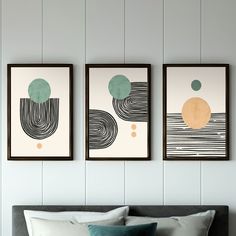 three framed art pieces hang on the wall above a bed