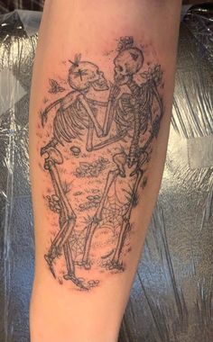 a couple of skeleton tattoos on the leg