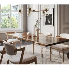 a dining room table with chairs and vases on the top, in front of a window