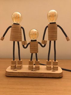 two wooden figurines holding hands with light bulbs