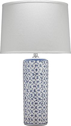 a blue and white table lamp with a white shade on the top, in front of a white background